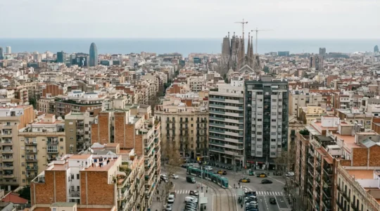 Vista panorámica de Barcelona con edificios residenciales y mar Mediterráneo, precio vivienda comparativa
